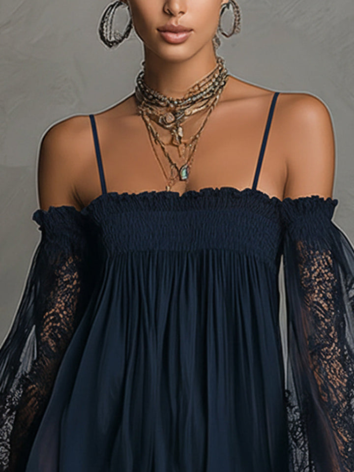 Close-up on top of navy off-shoulder dress with lace sleeves, layered necklaces, hoop earrings, in studio setting.