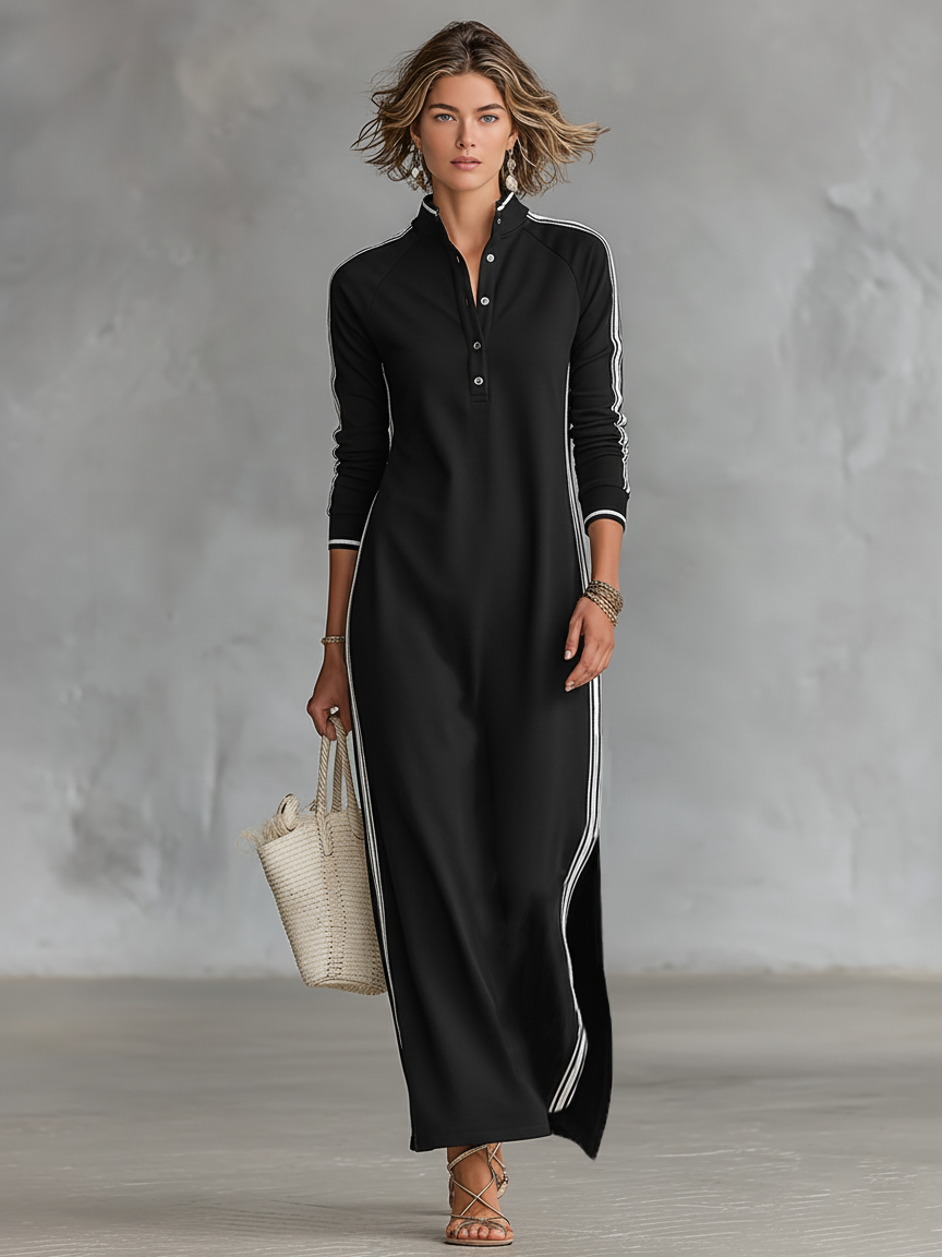Black maxi dress with vertical stripes, worn by a person holding a woven tote. Neutral indoor background.