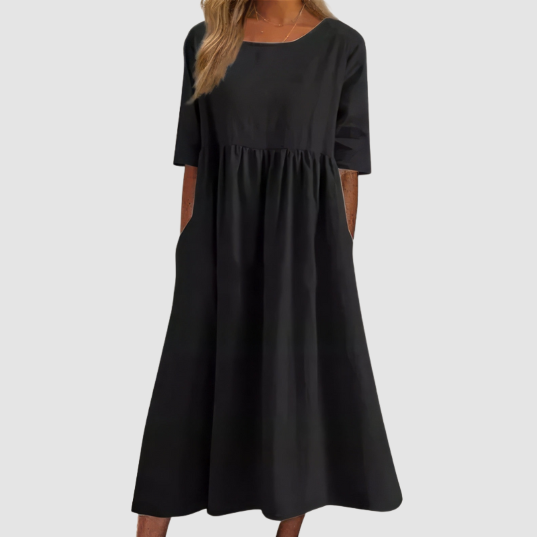 Black breezy dress with elbow-length sleeves in a studio setting.