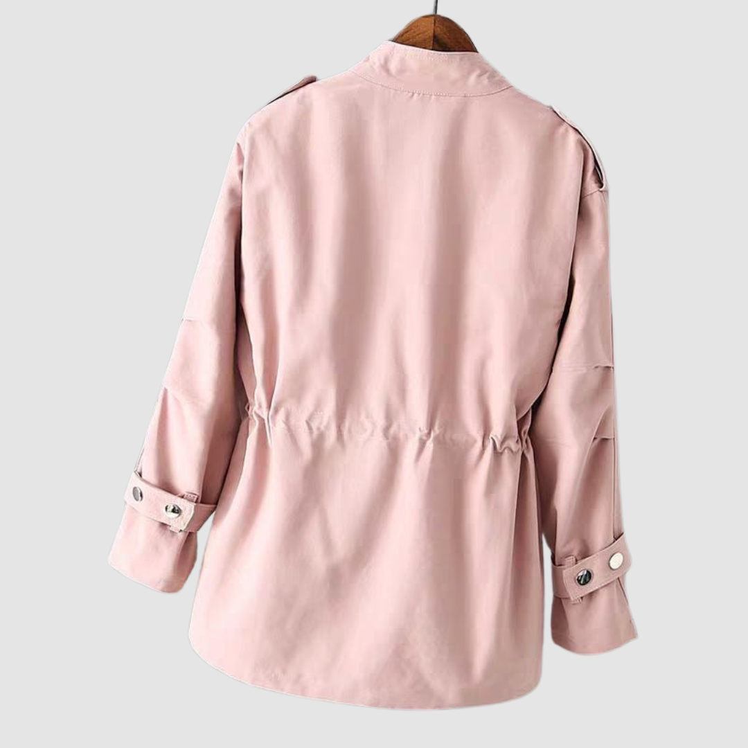 Back view of a light pink jacket with cinched waist and button details on cuffs, hanging on a white background.