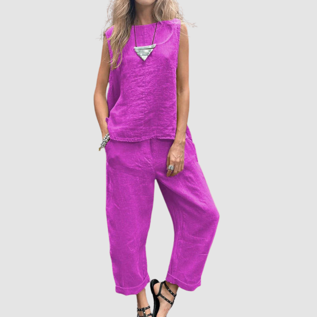 Bold pink two-piece summer set with sleeveless top and loose pants, worn by model, gray background.
