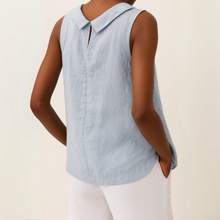 Back view of light blue sleeveless top with roll collar, model in white pants, light background.