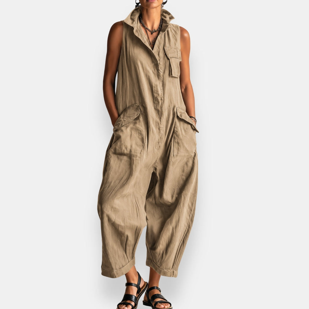Beige sleeveless cargo jumpsuit with spacious pockets, button-front style, worn by a model standing, studio background.