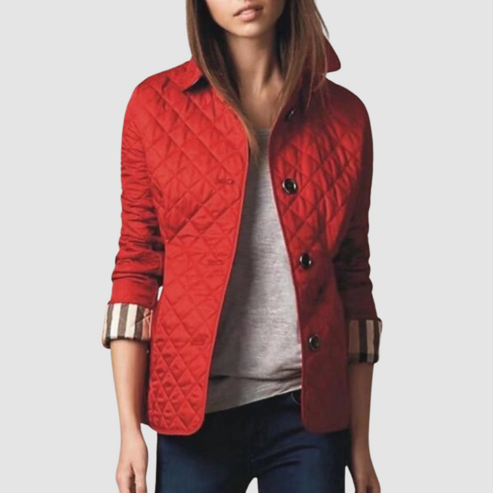 Red quilted jacket with buttons, worn over gray top and jeans on a model against a light background.