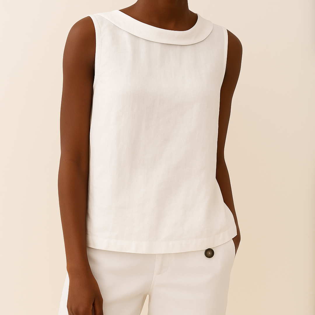 White sleeveless top with roll collar on model, styled with matching pants, set against a light background.