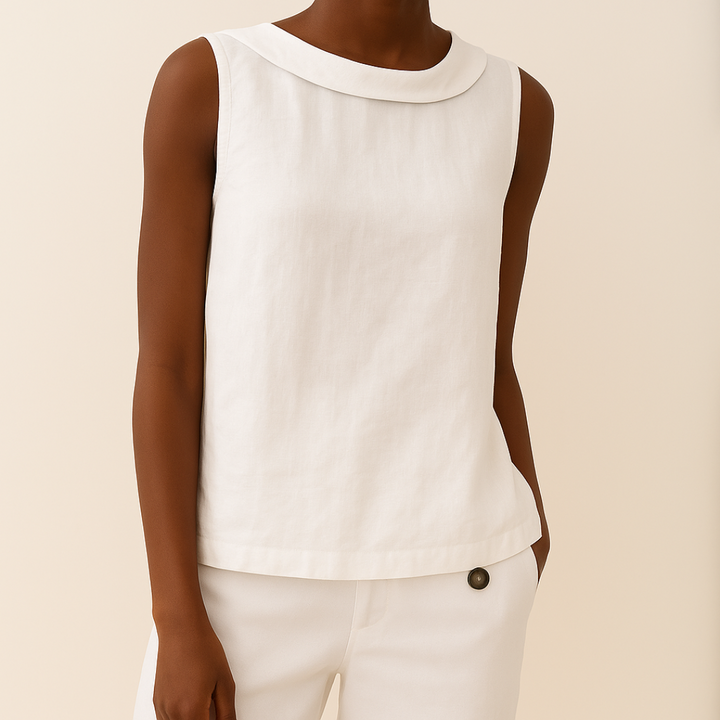 White sleeveless top with roll collar on model, styled with matching pants, set against a light background.