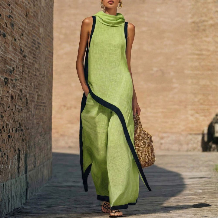 Elegant green sleeveless outfit with black trim, worn by a person carrying a woven bag, outdoor brick wall backdrop.