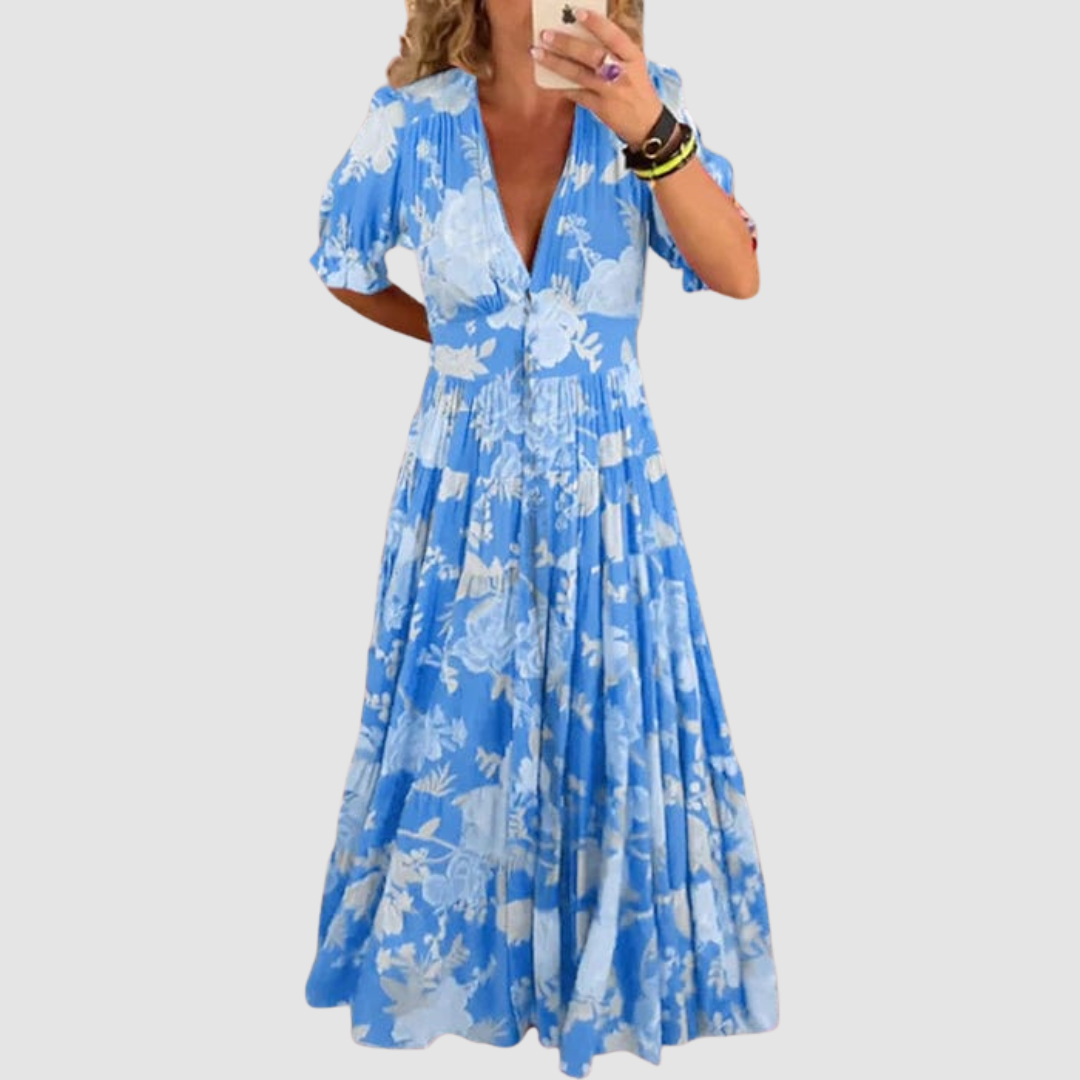 Blue floral long dress with short sleeves and a voluminous skirt, displayed against a neutral background.