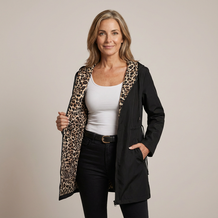 Woman in black reversible hooded coat with leopard print lining, studio background.