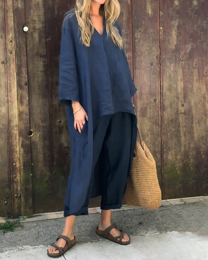 Navy set styled with woven bag and sandals against wooden wall.