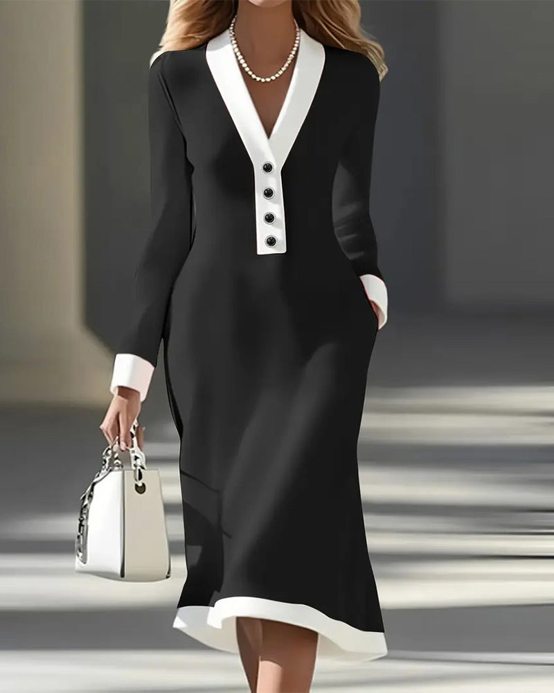 Black long-sleeve dress with white trim and buttons, accessorized with a pearl necklace and white handbag, in an urban setting.