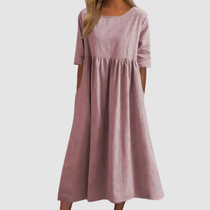 Soft pink breezy dress with elbow-length sleeves in a studio setting.