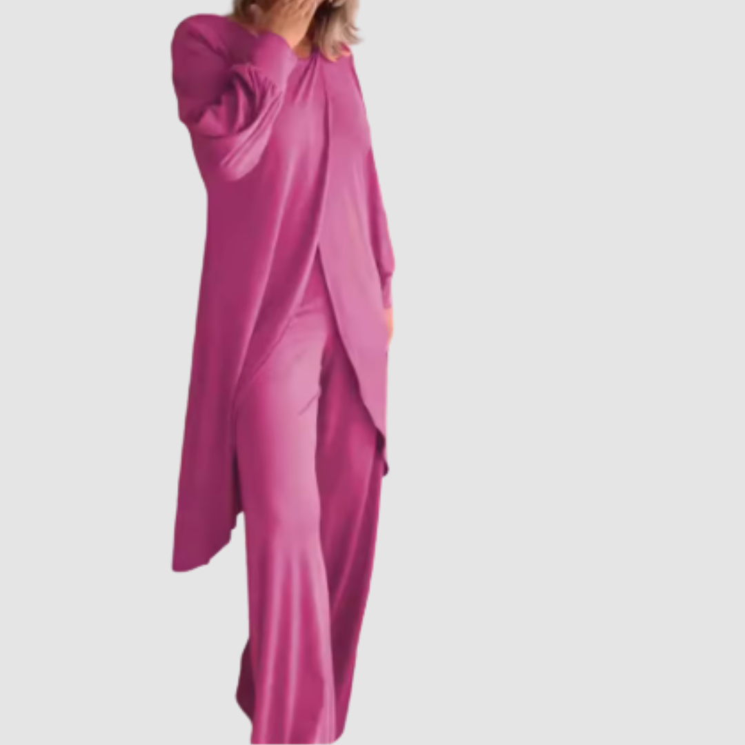Model wearing a pink long-sleeve 2-piece set in a studio, hand covering face, white background.