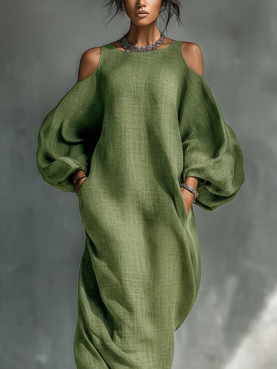 Close-up of a green maxi dress highlighting cutout shoulders and voluminous sleeves in a studio.