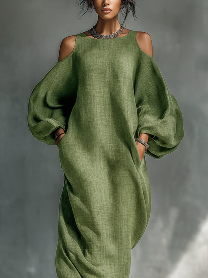 Close-up of a green maxi dress highlighting cutout shoulders and voluminous sleeves in a studio.