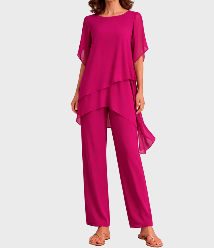 Bright pink two-piece set with flowing top and pants on model, front view in studio setting.