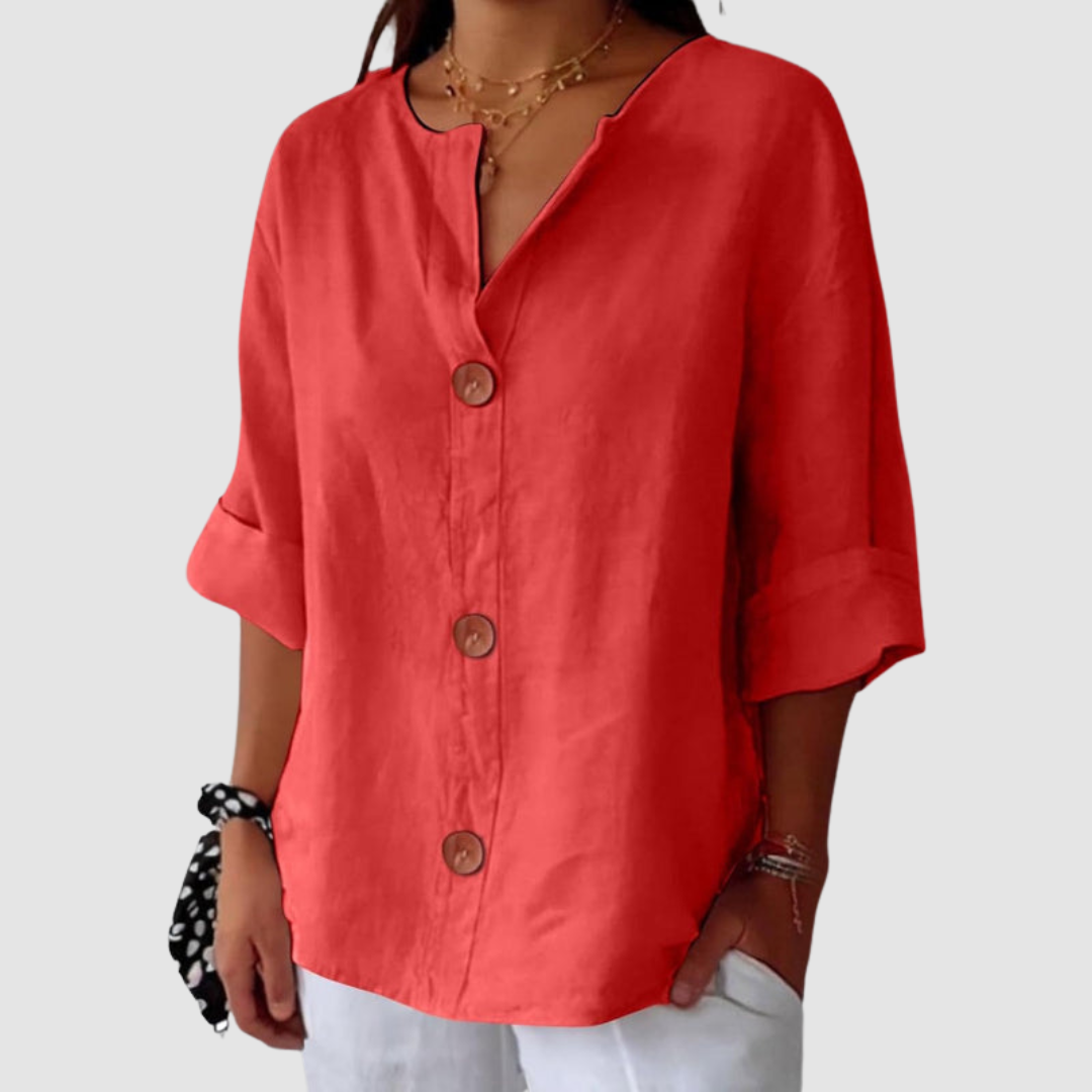 Coral casual blouse, loose-fitting with large buttons, against a minimalist backdrop.