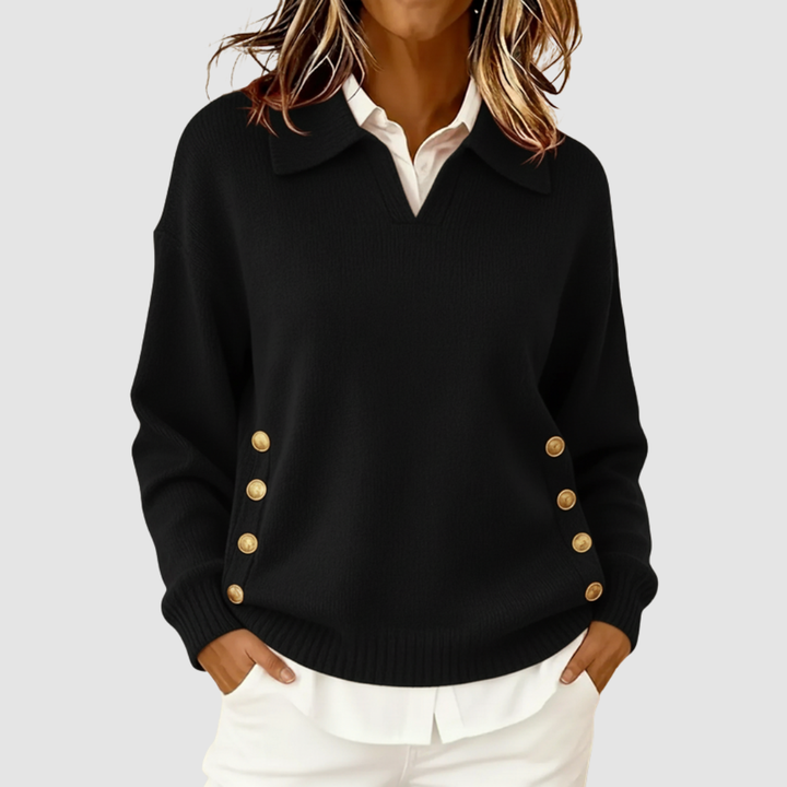 Elegant black knitted sweater with gold buttons on sides, worn over a white shirt against a light grey background.