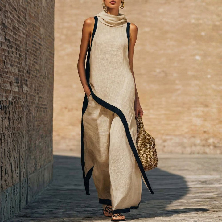 Elegant beige sleeveless outfit with black trim, worn by a person carrying a woven bag, outdoor brick wall backdrop.