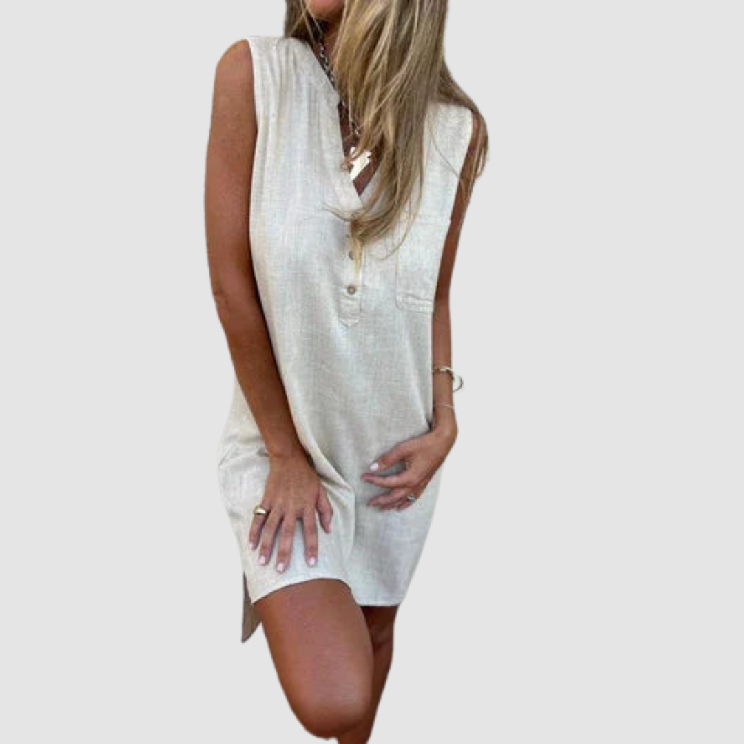 Woman in a light-colored sleeveless dress with button details, posing with one knee bent. Studio background.