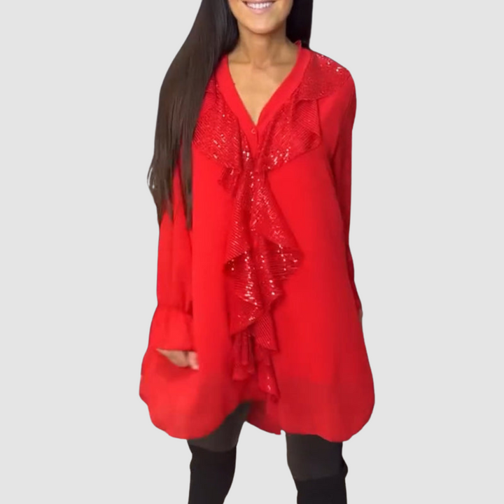 Vibrant red blouse with ruffled details, styled with black leggings in a studio.