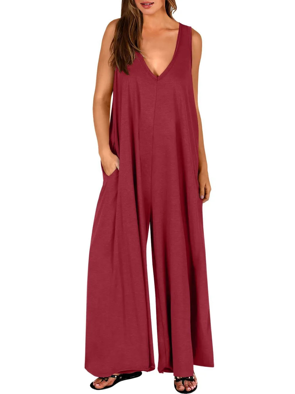 Red V-neck jumpsuit with wide legs, modeled in a studio with a white background.
