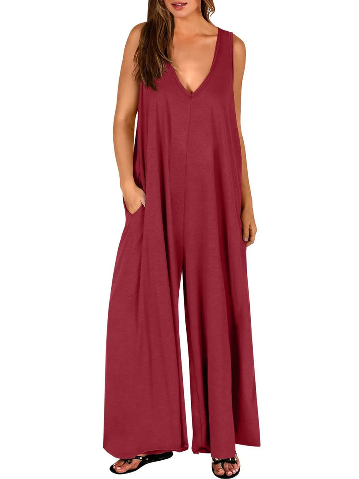 Red V-neck jumpsuit with wide legs, modeled in a studio with a white background.