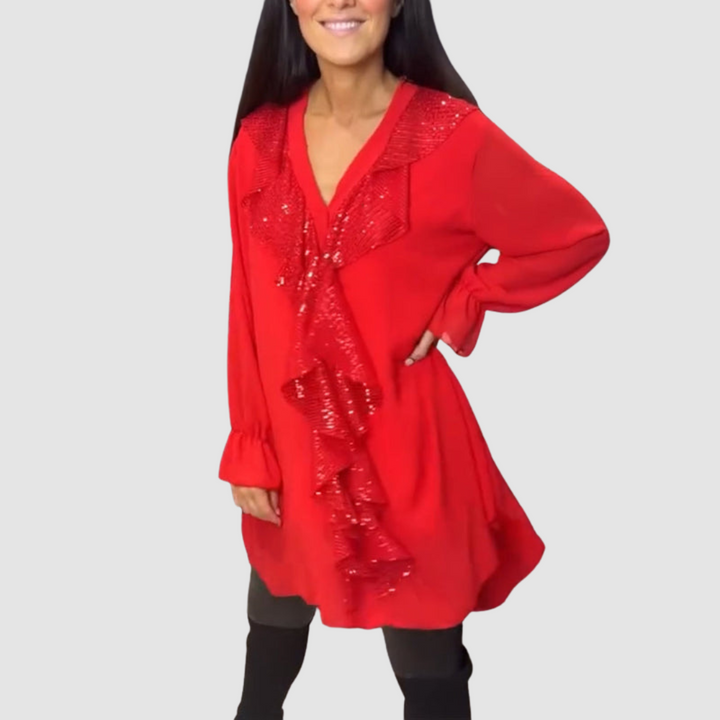 Red blouse adorned with shiny ruffles, accessorized with leggings in a bright studio.