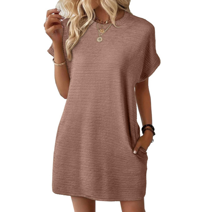 Warm taupe casual dress featuring a relaxed fit and short sleeves, styled elegantly with jewelry in a studio.