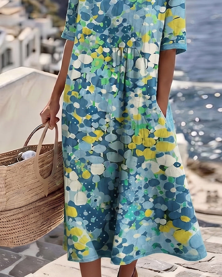 Close-up of blue and yellow floral dress by the sea with wicker bag, coastal view.