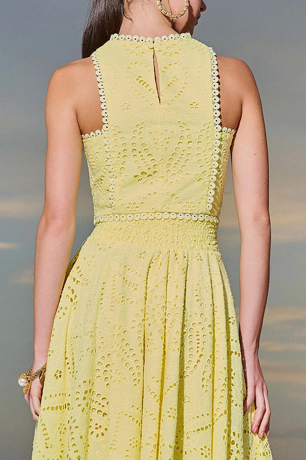 Back view of a yellow embroidered top and high-waist maxi skirt worn by a model against a sunset.