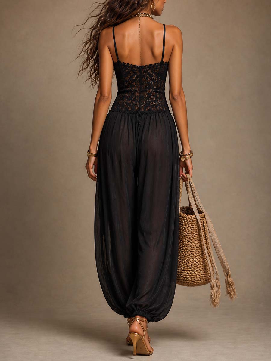 Back view of black lace and flowy jumpsuit, with a braided bag and heels against a studio backdrop.