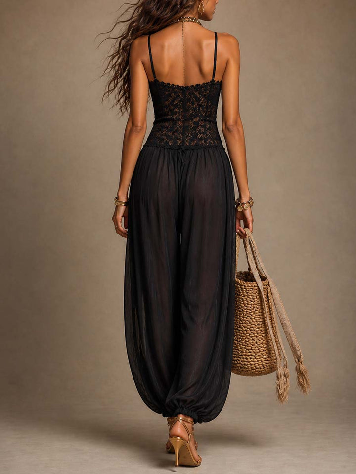 Back view of black lace and flowy jumpsuit, with a braided bag and heels against a studio backdrop.