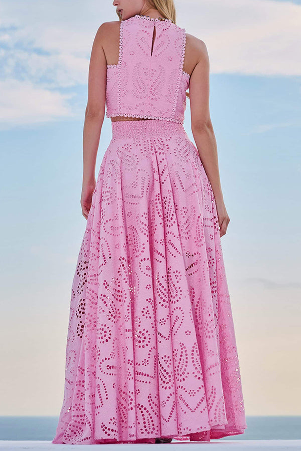 Back view of a pink embroidered top and high-waist maxi skirt worn by a model against a sky backdrop.