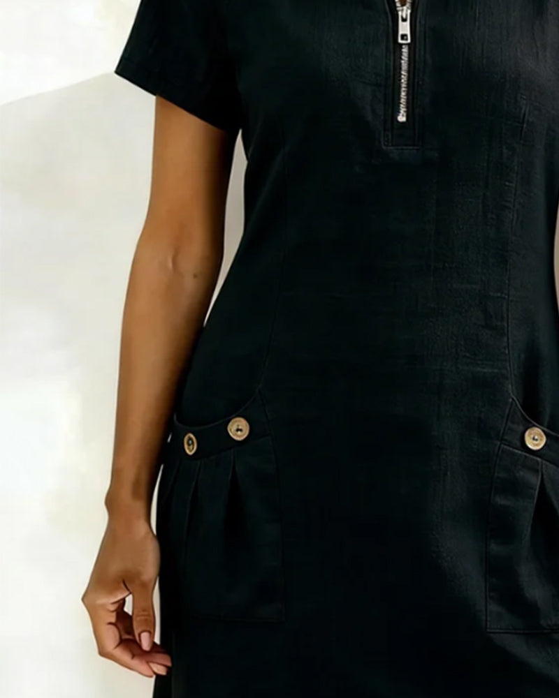 Close-up of black dress with buttoned pockets in a studio setting.