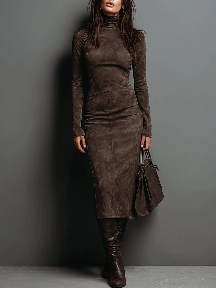 Model wearing a brown suede maxi dress with long sleeves in a studio setting. Accessories include a matching handbag and knee-high boots.