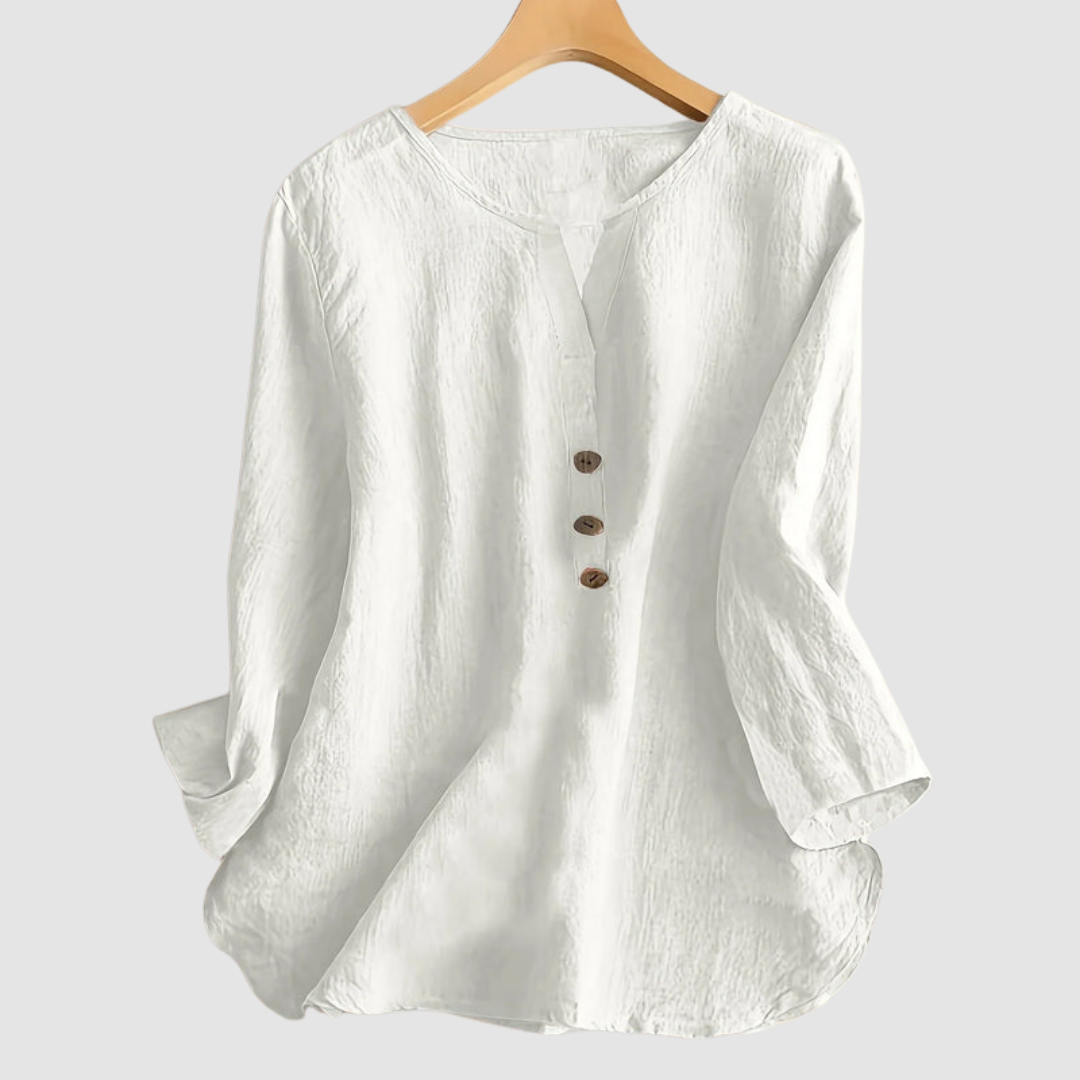 White casual blouse with button detail displayed on a hanger against a plain background.