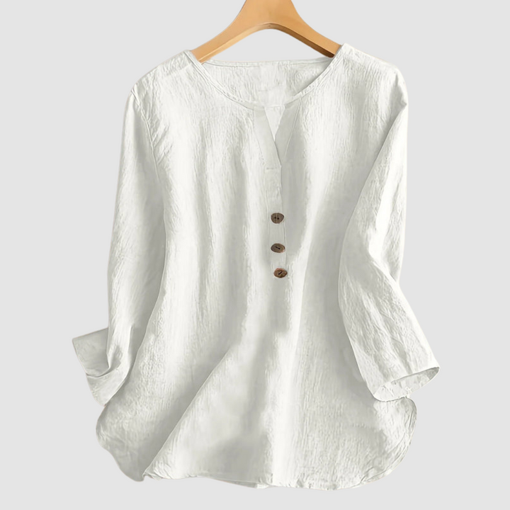White casual blouse with button detail displayed on a hanger against a plain background.