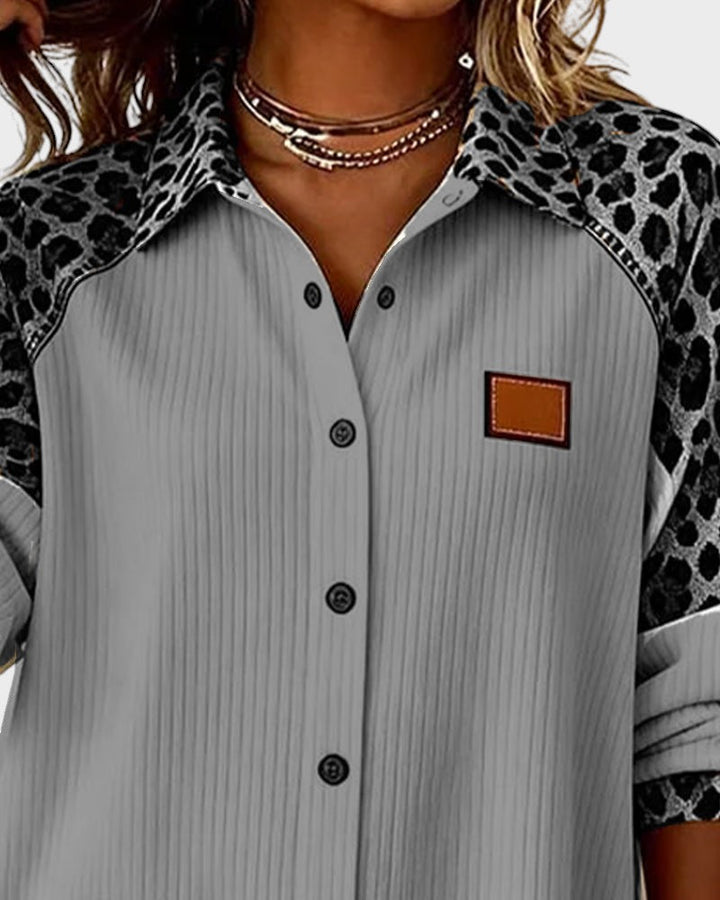 Close-up of leopard print button-down shirt top. Gray shirt with patterned collar and black buttons in a studio.