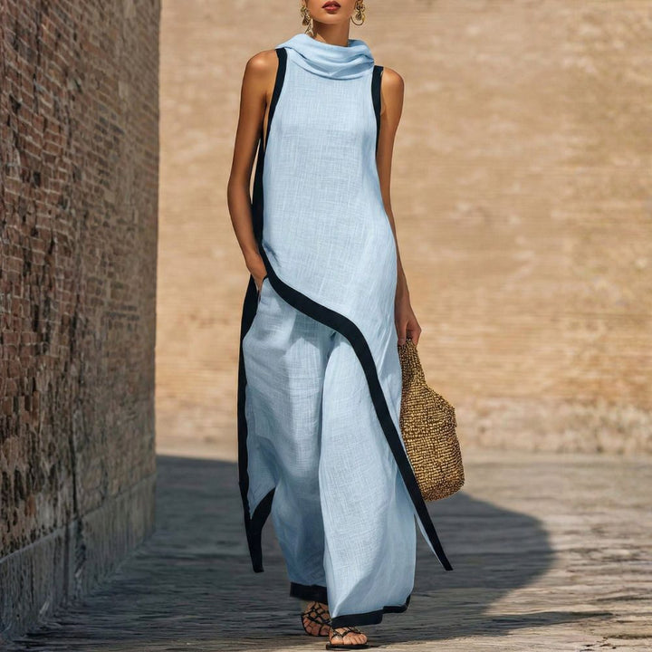 Elegant light blue sleeveless outfit with black trim, worn by a person carrying a woven bag, outdoor brick wall backdrop.