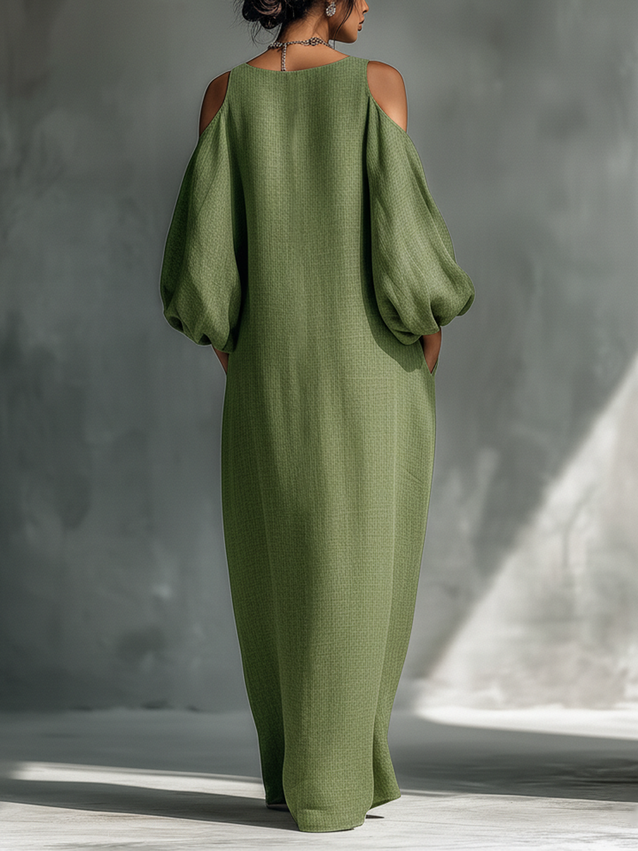 Back view of a green maxi dress with cutout shoulders and puff sleeves, modeled in a studio.
