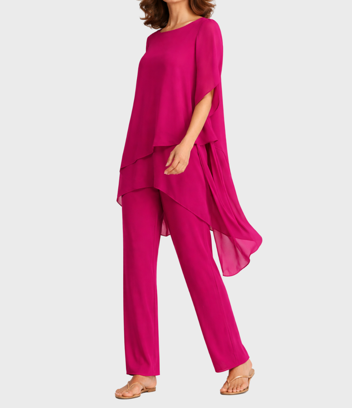Pink two-piece outfit with an asymmetrical hem, model side view in studio setting.
