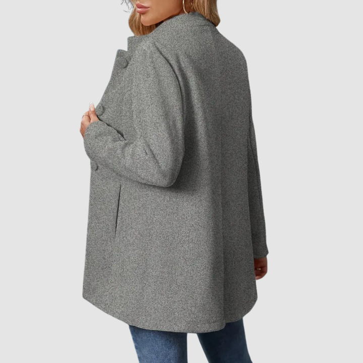 Back view of gray jacket with large buttons, worn over jeans, against a plain background.