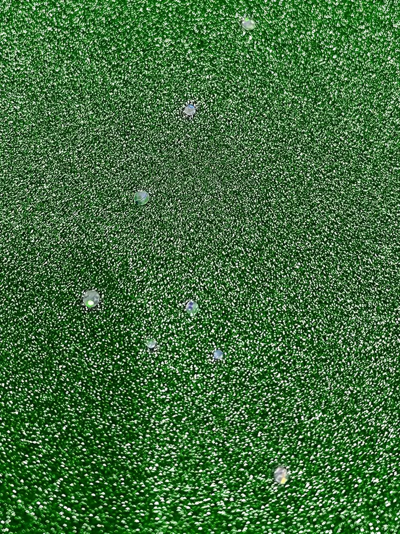 Detailed view of green dress fabric featuring sparkling dots and folds, showcasing texture and shine.