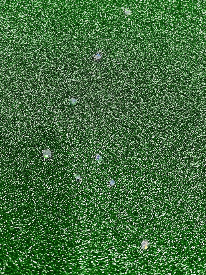 Detailed view of green dress fabric featuring sparkling dots and folds, showcasing texture and shine.