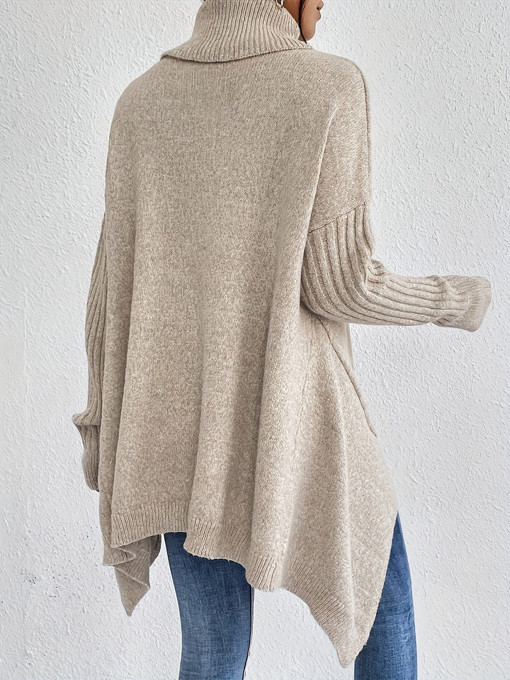 Back view of beige turtleneck sweater with ribbed sleeves, worn with jeans, against a plain white background.
