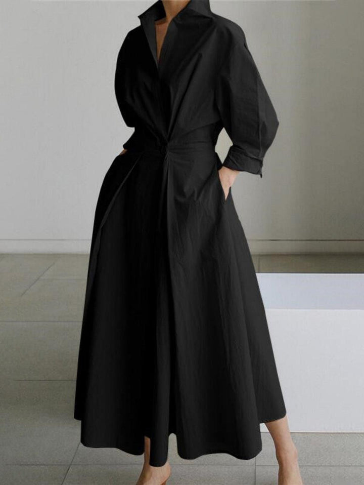 Black midi dress with button lapel and loose fit, worn indoors on a light tile floor.