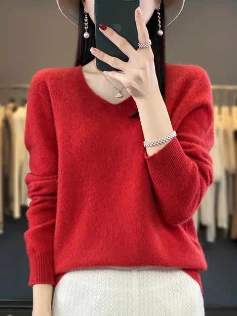Person in a vibrant red loose knit sweater, posing in a fashion studio.