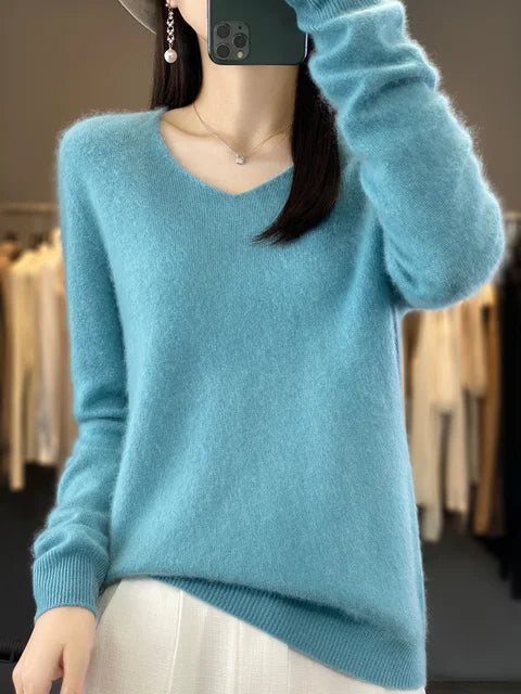 Person wearing a light blue loose knit sweater in a contemporary fashion studio.