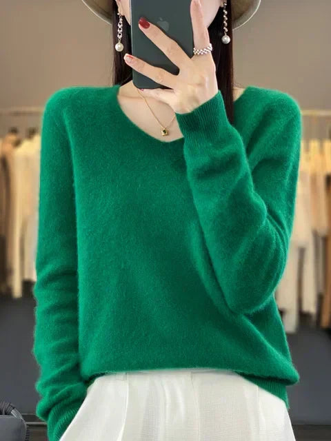 Person wearing a green loose knit sweater, set in a chic fashion studio.